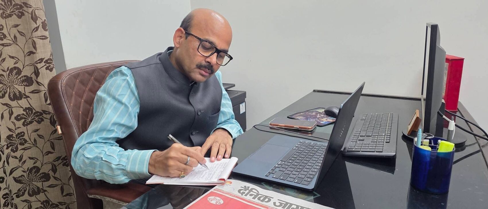 Harish Dwivedi reviewing and signing papers at his working desk