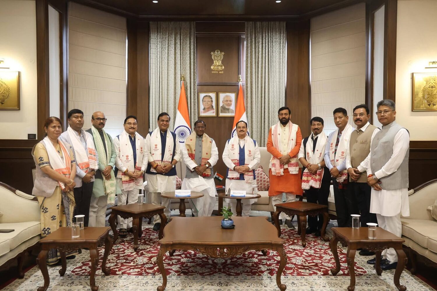 Harish Dwivedi with a delegation in an official reception room displaying the national flag