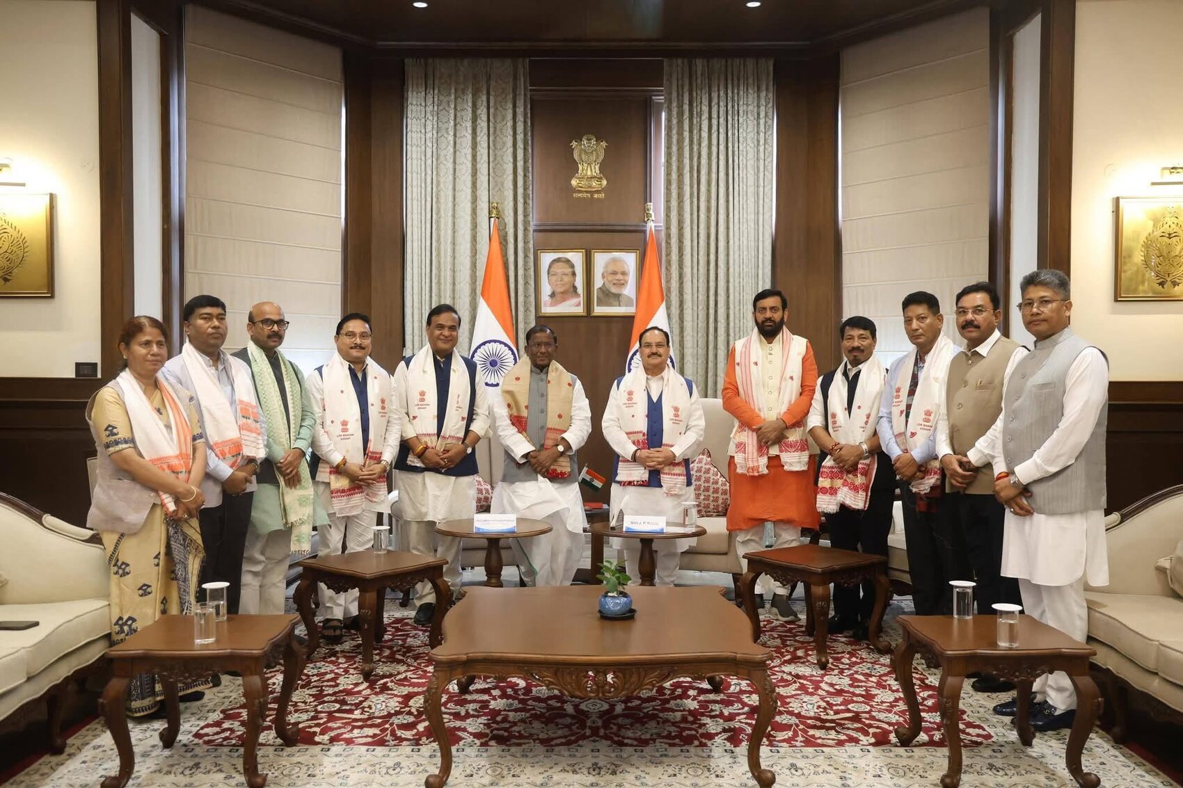 Harish Dwivedi with a delegation in an official reception room with the national flag
