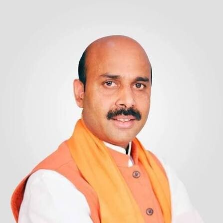 Portrait of Harish Dwivedi wearing an orange sadri over a white kurta