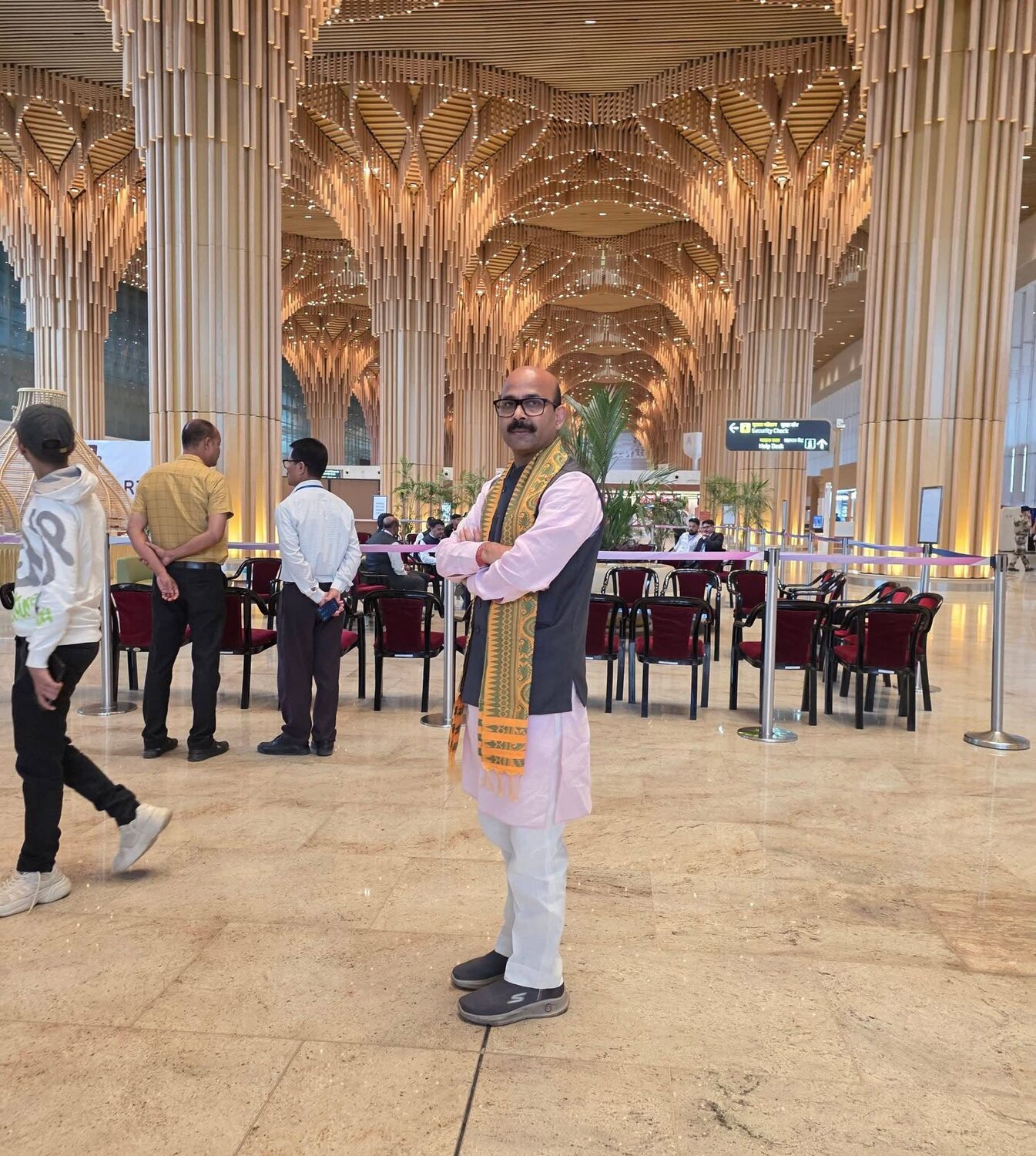 Harish Dwivedi walking through a modern airport terminal